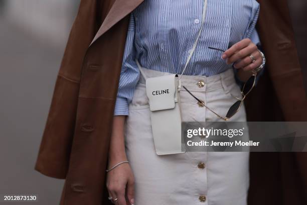 Tara Tut seen wearing Celine gold Triomphe sunglasses, gold earrings, & Other Stories blue / white striped buttoned blouse shirt, Zara white denim /...