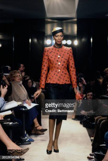 Model wearing a black pencil skirt and a tailored red jacket from Chanel's collection for spring and summer, Paris, January 30th 1979.