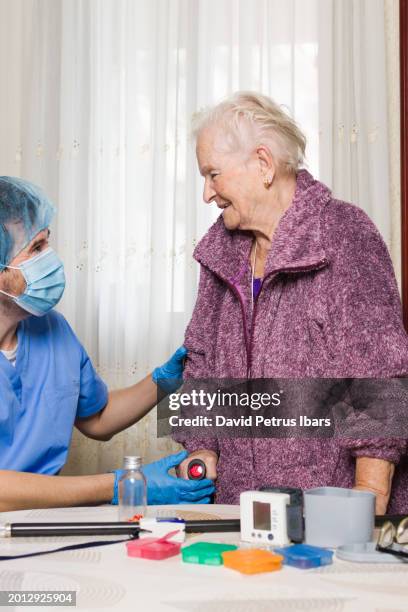 doctor helping injured patient learn to walk with a crutch at home - injured nurse stock pictures, royalty-free photos & images