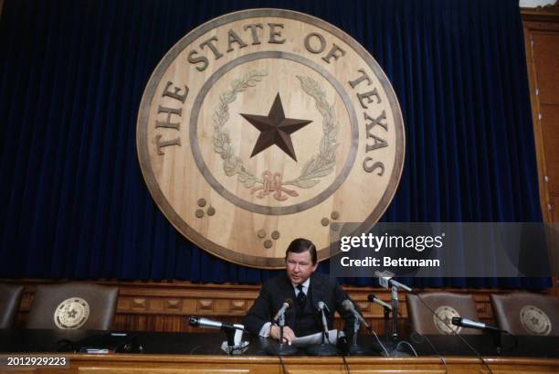 Texas Senator John Tower seated in front of the state seal in the Texas State Capitol, Austin, 1978.