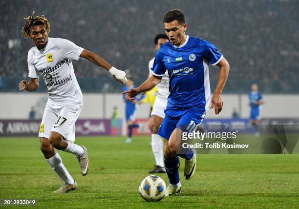 Ruslanbek Jiyanov of PFC Navbahor Namangan runs with the ball whilst under pressure from Ahmed Al Ghamdi of Al Ittihad during the AFC Champions...