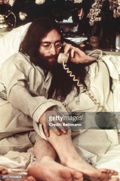 Married musicians John Lennon & Yoko Ono being interviewed in bed during their "Bed-in for Peace" in Montreal.