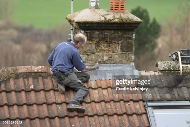 roofer working and repairing a house roof in the uk - roofer stock pictures, royalty-free photos & images