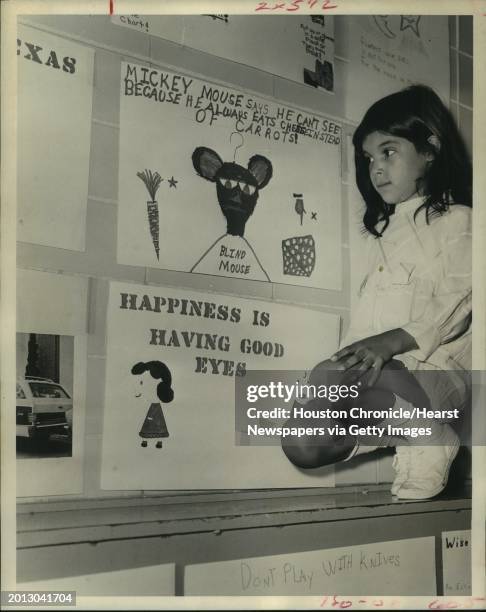 Mary Lisa Leal, inspects her competition today in a poster contest aimed at education youngsters to the importance of good eye safety and health. Her...