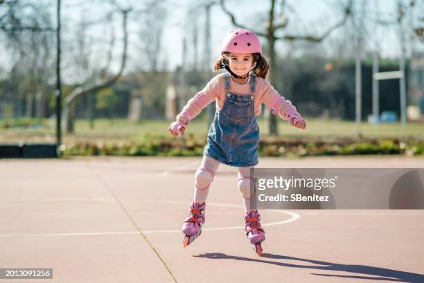 young inline skater enjoying a sunny day in the park - roller skates stock-fotos und bilder
