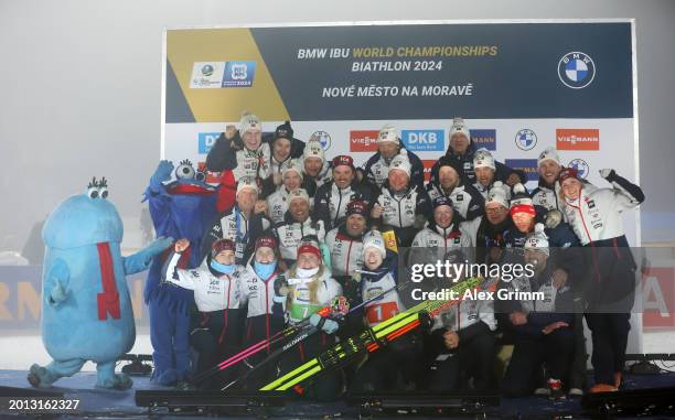 Third placed Johannes Thingnes Boe and Ingrid Landmark Tandrevold of Norway celebrate with teammates on the podium following the Single Mixed Relay...