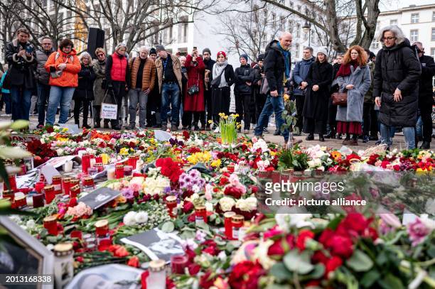 February 2024, Berlin: People stand in front of flowers at a demonstration against the Russian government in front of the Russian embassy in...