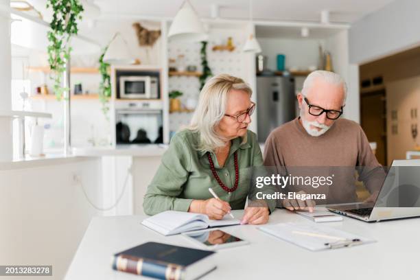 senior couple using laptop while planning their home budget, - ageing population stock-fotos und bilder