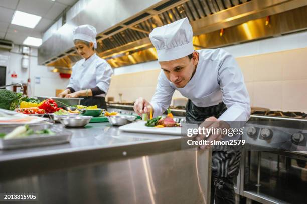 artistry unveiled: male student showcases food decoration skills in cooking class - unveiled stock pictures, royalty-free photos & images