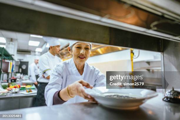 serving excellence: chef transfers culinary creations to waitress in restaurant setting - pub reopening stock pictures, royalty-free photos & images