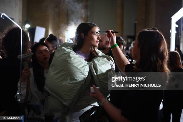 Model is prepared back-stage ahead of the catwalk presentation for Norwegian fashion house Holzweiler for their Autumn/Winter 2024 collection during...
