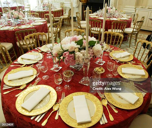 Table settings, prepared for the state dinner for Philippines President Gloria Macapagal Arroyo, adorn a table in the State Dining Room of the White...