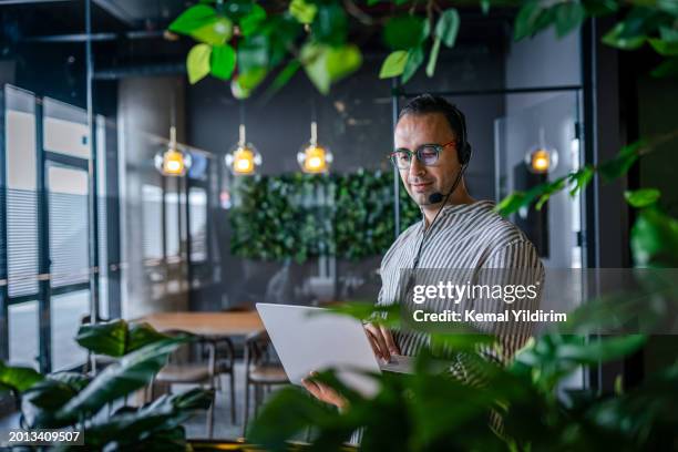 portrait of a handsome young man working in a call center - saleswoman stock pictures, royalty-free photos & images
