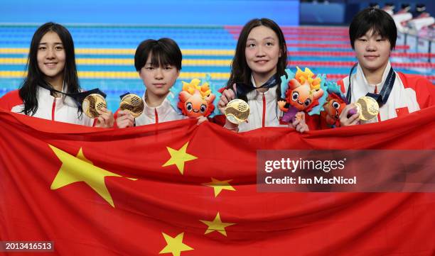 Gold Medalists, Yanhan Ai, Zhenqi Gong, Bingjie Li and Peiqi Yang of Team People's Republic of China pose with their medals and their country's flag...