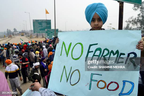 Boy holds a placard during a protest by farmers to demand minimum crop prices, near the Haryana-Punjab state border at Shambhu in Patiala district...