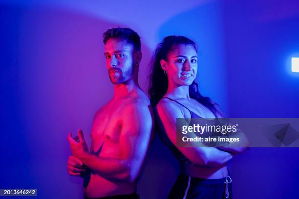 athlete people posing together while lit by red and blue neon lights. - sport determination stock pictures, royalty-free photos & images