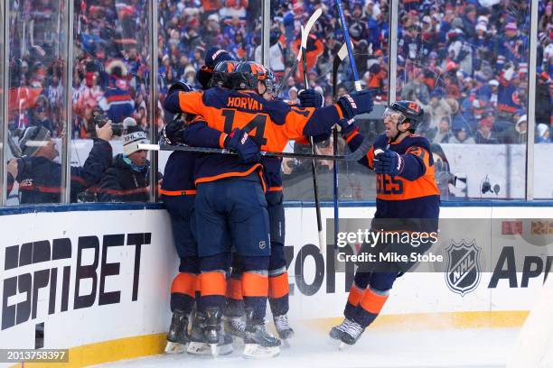 Mathew Barzal of the New York Islanders is congratulated by his teammates after scoring a goal against the New York Rangers during the first period...