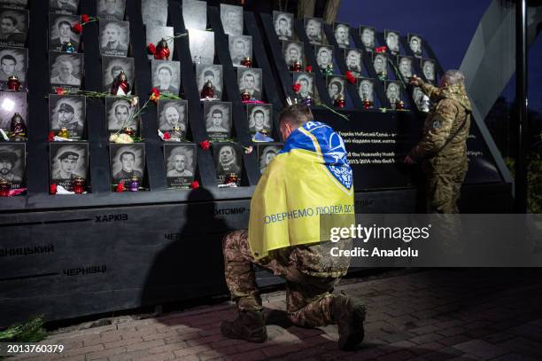 Soldier kneels as Kyiv residents attend a memorial service to commemorate protesters killed during the Revolution of Dignity in 2014 in Kyiv, Ukraine...