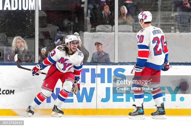 Mika Zibanejad of the New York Rangers is congratulated by Chris Kreider after scoring the game-tying goal against the New York Islanders during the...