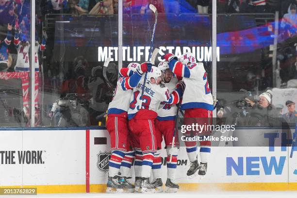 Mika Zibanejad of the New York Rangers is congratulated by his teammates after scoring the game-tying goal against the New York Islanders during the...