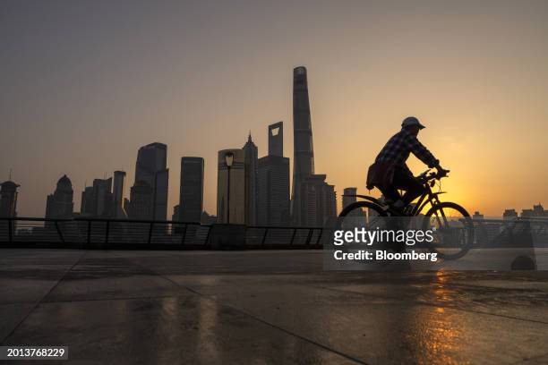 Cyclist travels past buildings in Pudong's Lujiazui Financial District in Shanghai, China, on Monday, Feb. 19, 2024. Chinese stocks saw modest gains...