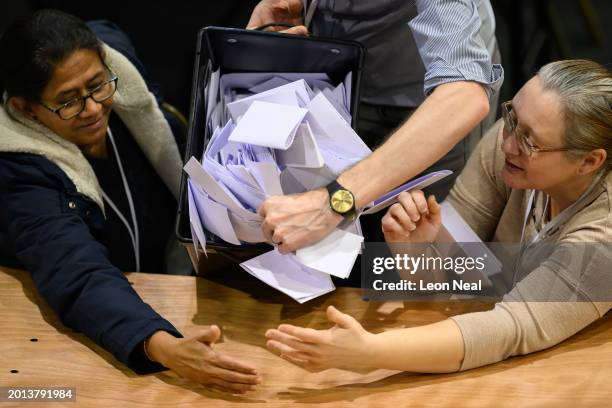 Count staff look on as a box of ballot papers is emptied at the Wellingborough by-election count centre in Kettering Leisure Village on February 15,...