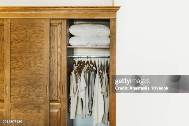 brown wooden wardrobe with clothes and pillows inside. - walk in closet stock pictures, royalty-free photos & images