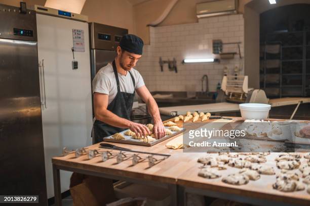 artisan baker setting pastries on a baking tray - bakning business bildbanksfoton och bilder