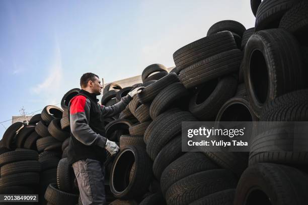 man working at scrap tires in the recycling bin. - tyre stock pictures, royalty-free photos & images