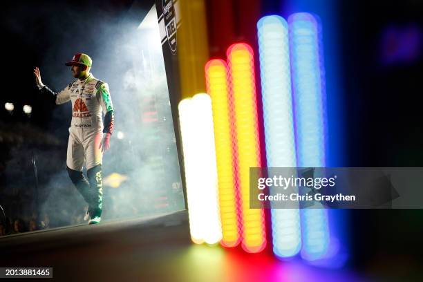 William Byron, driver of the Axalta Chevrolet, waves to fans as he walks onstage during driver intros prior to the NASCAR Cup Series Bluegreen...