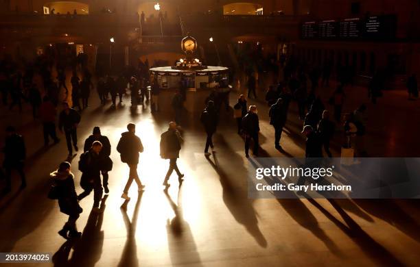 People walk through Grand Central Terminal as the sun rises through the eastern facade of the building on February 15, in New York City.