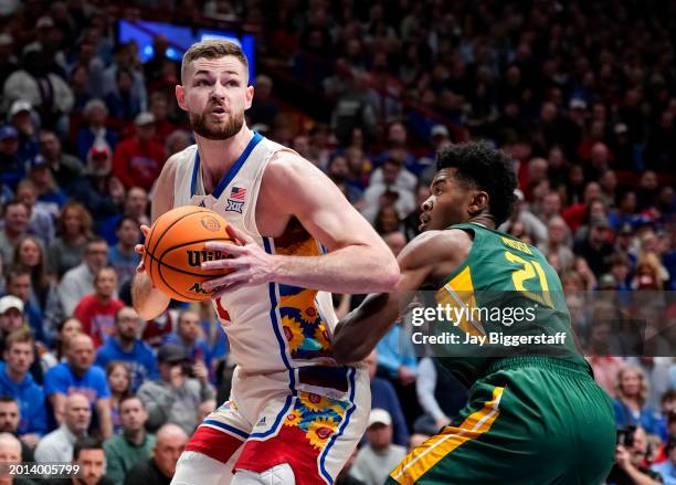 Hunter Dickinson of the Kansas Jayhawks drives against Yves Missi of the Baylor Bears during the first half at Allen Fieldhouse on February 10, 2024...