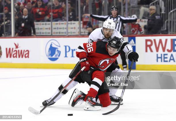 Jack Hughes of the New Jersey Devils heads for the net as Viktor Arvidsson of the Los Angeles Kings defends during the second period at Prudential...