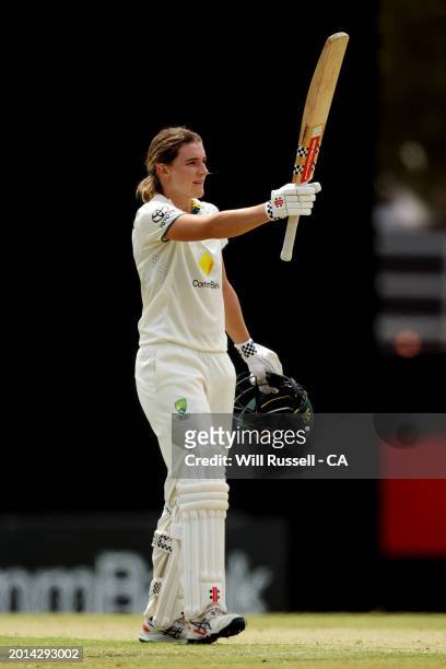 Annabel Sutherland of Australia raises her bat after scoring 100 runs during day two of the Women's Test match between Australia and South Africa at...