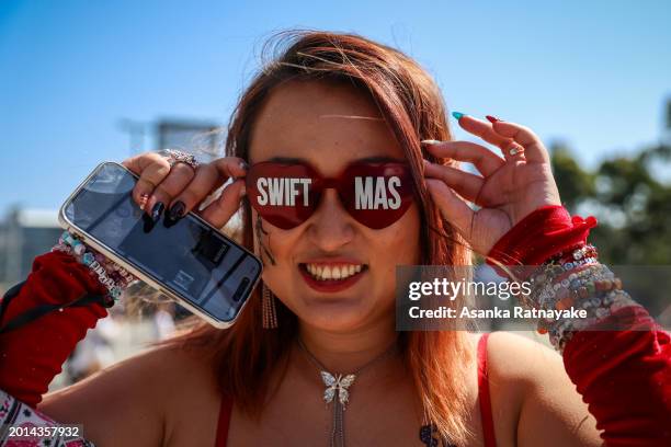 Taylor Swift fan also known as a "Swiftie" poses for a photo while wearing glasses that read "Swifmas" before Swift's "Taylor Swift | The Eras Tour"...