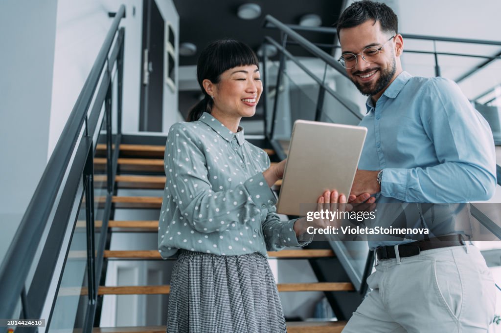 Business colleagues talking on stairs in the office.