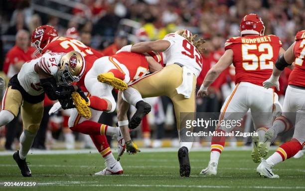 Dre Greenlaw and Chase Young of the San Francisco 49ers tackle Travis Kelce of the Kansas City Chiefs during Super Bowl LVIII at Allegiant Stadium on...