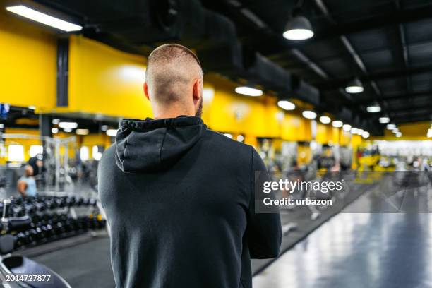 rear-view of a young muscular man at the gym - posterior view of arm muscles stock pictures, royalty-free photos & images