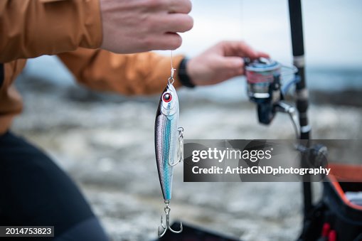 Close-up of man preparing fishing lures for shore fishing. Close-up of man preparing fishing lures for shore fishing.