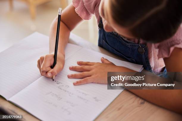 young girl sitting at a desk at home and doing her homework - kid handwriting stock pictures, royalty-free photos & images