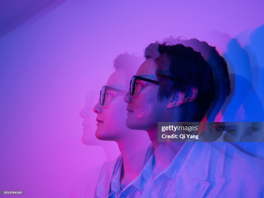 Multiple exposure of Asian businessman in neon lights
