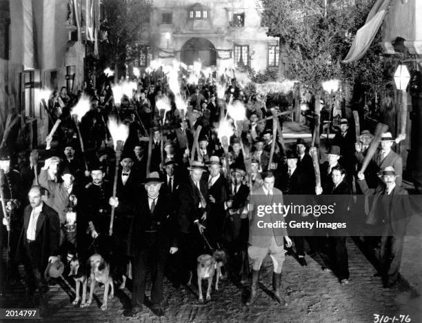 An angry mob holding torches in a still from the film, 'Frankenstein,' directed by James Whale, 1931.