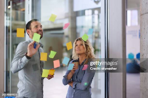business colleagues making mind map on a glass wall in the office. - mind map stock pictures, royalty-free photos & images