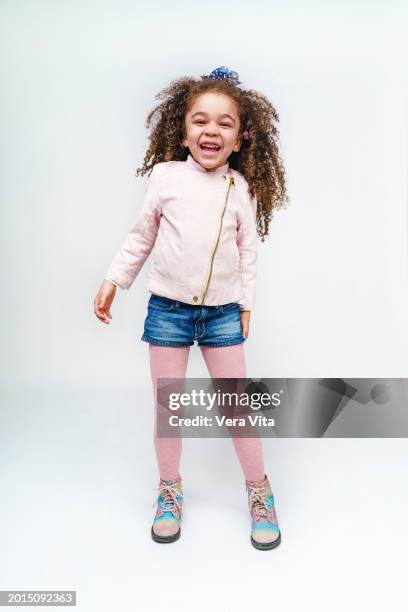 portrait of little girl with afro hairstyle standing isolated on white background. - young girl white background stock pictures, royalty-free photos & images