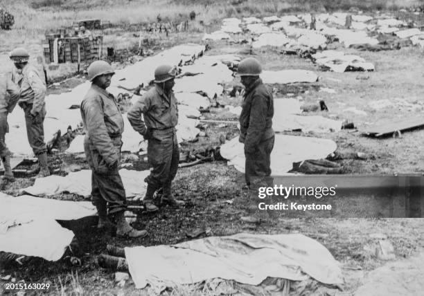 African American soldiers with the 603d Quartermaster Corps Graves Registration Company, United States First Army, collect and process the soldiers...