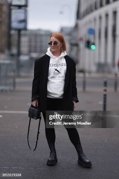 Elena Przkora seen wearing Miu Miu gold oval sunglasses, gold earrings, Hernameis pink oversized t-shirt, Hernameis white logo print pattern...