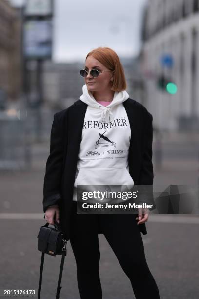 Elena Przkora seen wearing Miu Miu gold oval sunglasses, gold earrings, Hernameis pink oversized t-shirt, Hernameis white logo print pattern...