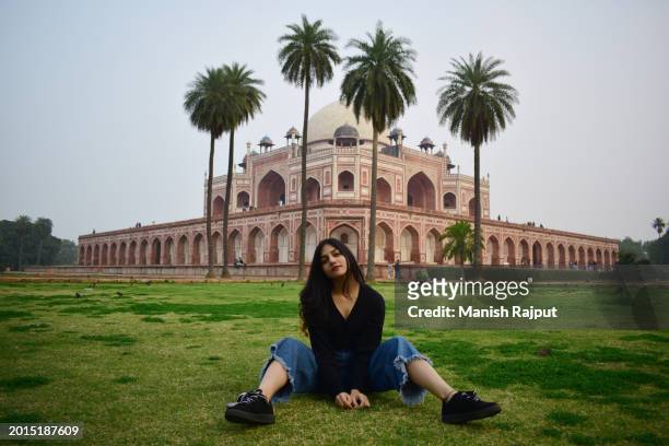 a indian tourist woman sitting near the monument. - humayans tomb stock pictures, royalty-free photos & images