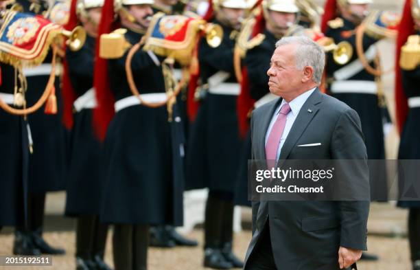 King Abdullah II of Jordan walks past the honor guard prior to a working lunch with French President Emmanuel Macron at Elysee Presidential Palace on...