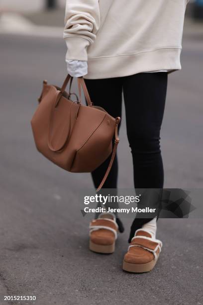 Elise Rozay seen wearing Hernameis creamy white logo print pattern oversized sweater, Zara black split leggings pants, Hernameis beige wool knit...